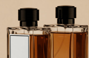 Deux flacons de parfum en verre remplis de liquide ambré, avec des capuchons noirs. L'un possède une étiquette blanche vierge sur un fond clair.