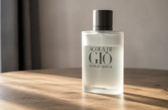 Flacon de parfum Acqua di Giò de Giorgio Armani posé sur une table en bois sous un éclairage doux.