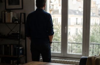 Homme qui observe à travers la fenêtre à l'horizon